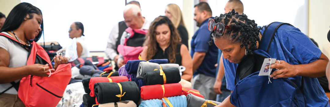 team members packing backpacks for foster youth
