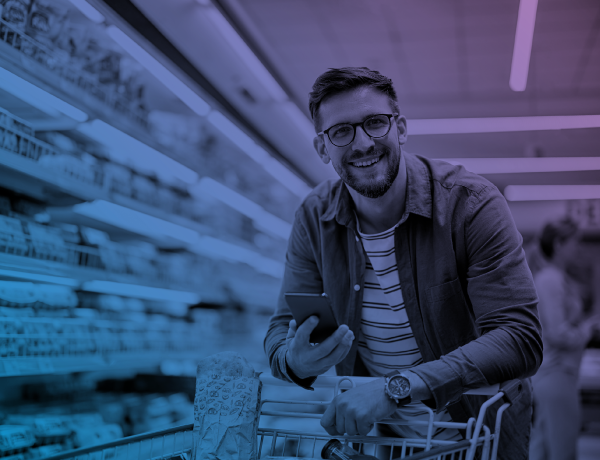 man holding phone pushing cart at supermarket