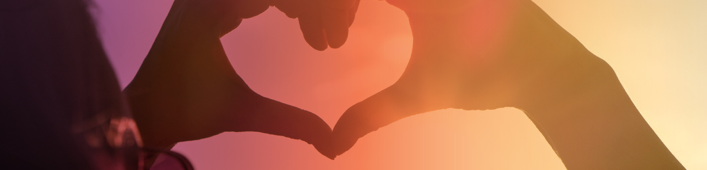 Girl holding hand-heart to sky