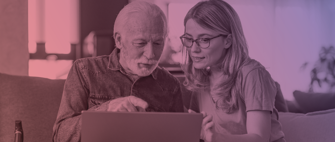 woman helping senior citizen at laptop