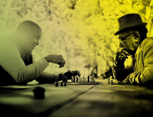 two men playing chess in the park