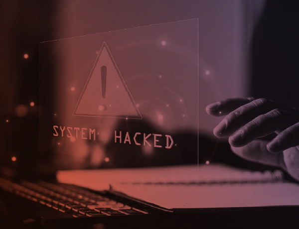 person at laptop with sign that says system hacked