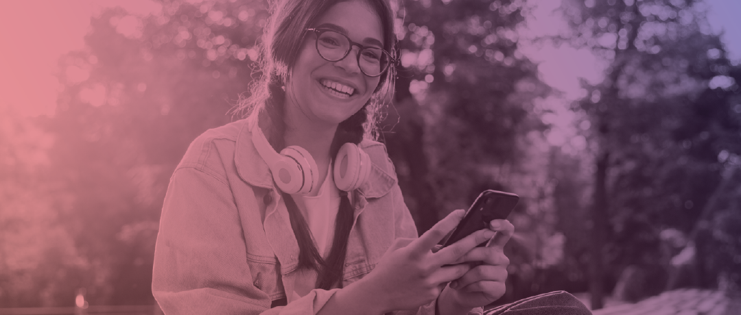 teen girl wearing headphones and holding her phone