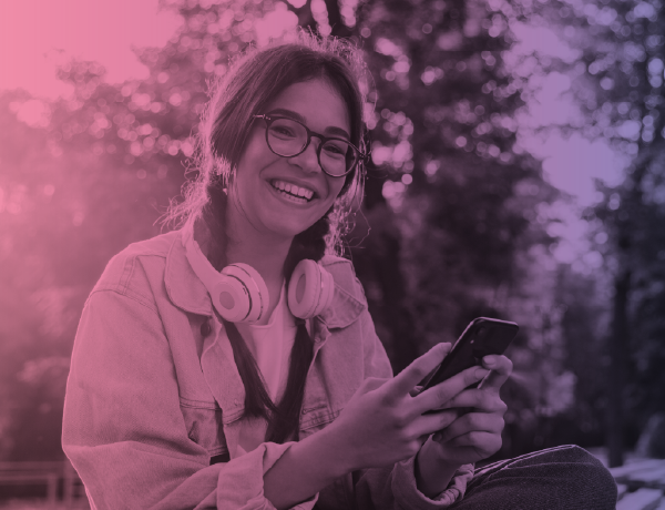 teen girl wearing headphones and holding her phone