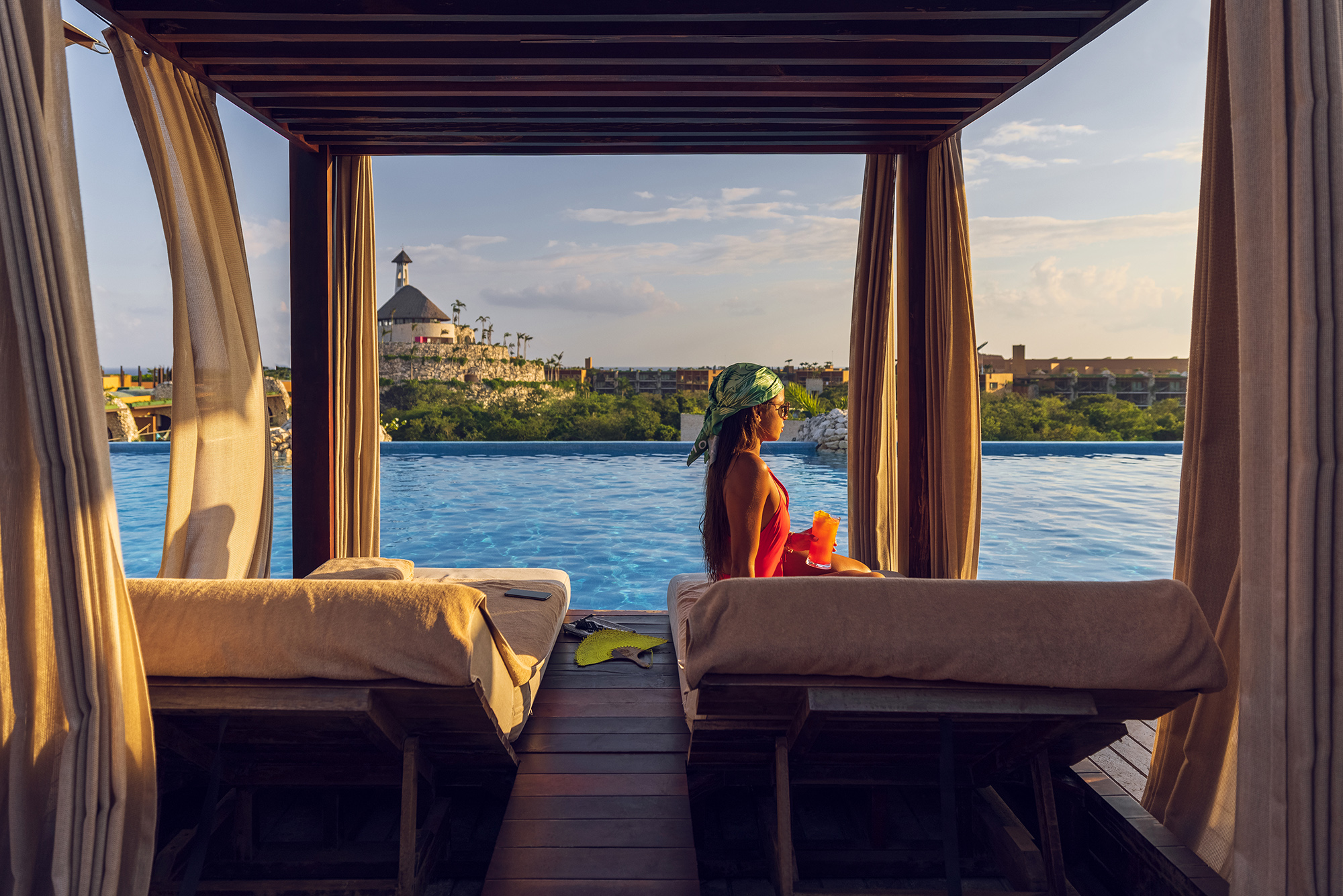 woman sitting on lounge chair in cabana